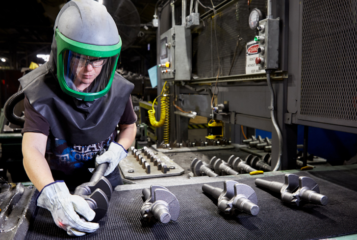 Foundry operator conducting quality assurance checks on cast iron parts post molding