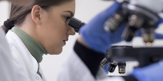 Kohler corporate lab technician reviewing results in a microscope demonstrating support of the foundry operations 