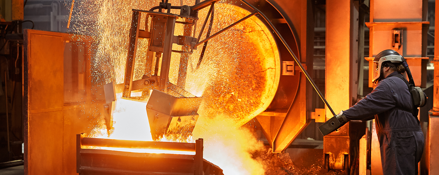 Cast Iron Foundry Operator deslagging molten iron bath